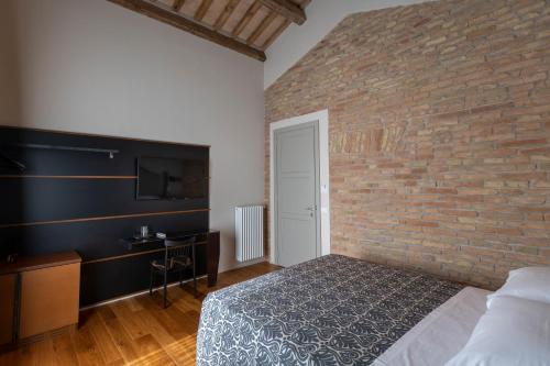 a bedroom with a brick wall and a bed at Sei Sequoie Nature & Charme in Ravenna