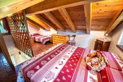 a bedroom with a bed in a room with wooden ceilings at Baita Mas Socina in Peio