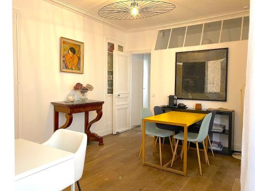 a living room with a table and a dining room at Real Parisian apartment with 2 bedrooms and AC in Paris