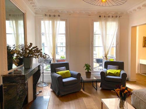 パリにあるReal Parisian apartment with 2 bedrooms and ACのリビングルーム(椅子2脚、ソファ付)