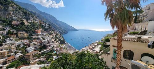a view of the amalfi coast with a palm tree at Casa Hellen Positano center in Positano