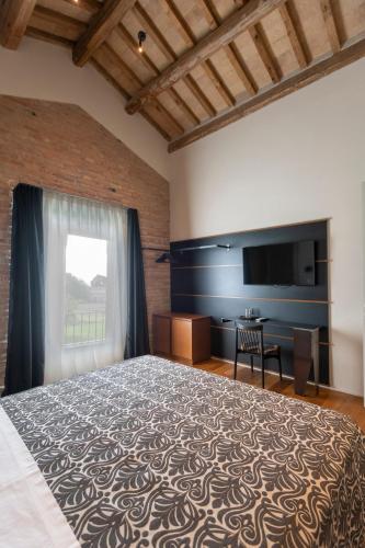 a bedroom with a large bed and a television at Sei Sequoie Nature & Charme in Ravenna