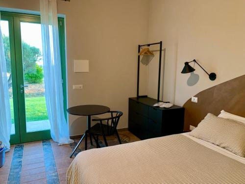 a bedroom with a bed and a table and a window at Il Poggio di Musignano in Musignano