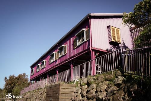 a pink house on top of a stone wall at Alishan Sunrise B&B in Fanlu