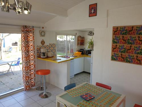 une cuisine et une salle à manger avec une table et un comptoir dans l'établissement Horizon, en bord de plage, à Marennes