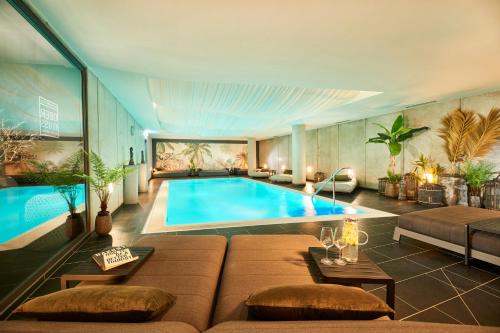 un soggiorno con piscina e divano di Designhotel ÜberFluss a Brema