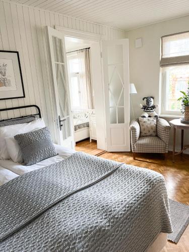 a bedroom with a bed and a chair and a window at Hapsal Dietrich apartemendid in Haapsalu