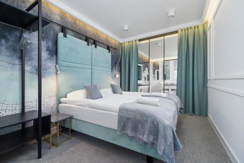 1 dormitorio con 1 cama grande y cortinas verdes en Riva Verona Apartments by Renters Prestige en Cracovia