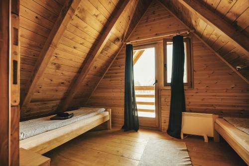 a bedroom in a wooden cabin with a window at Laguna Platz in Sremski Karlovci