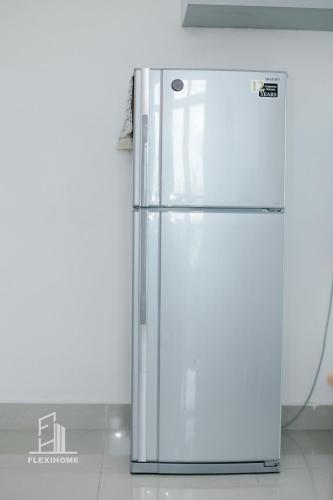 a white refrigerator sitting in a kitchen next to a wall at 10am-6pm, SAME DAY CHECK IN AND CHECK OUT, Work From Home, Shaftsbury-Cyberjaya, Comfy Home by Flexihome-MY in Cyberjaya