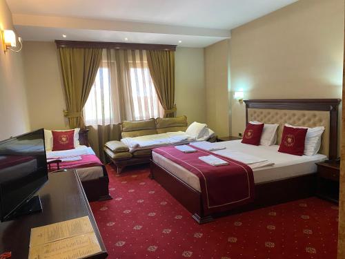 a hotel room with two beds and a couch at Hotel Kacinari in Prizren