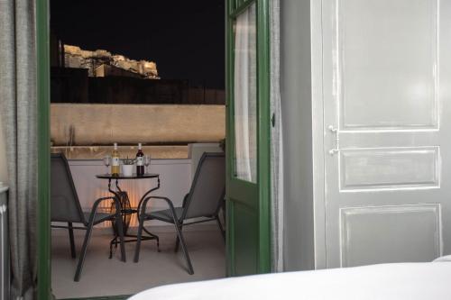 a door is open to a room with a bench at Pandrosos Divine Suites in Athens