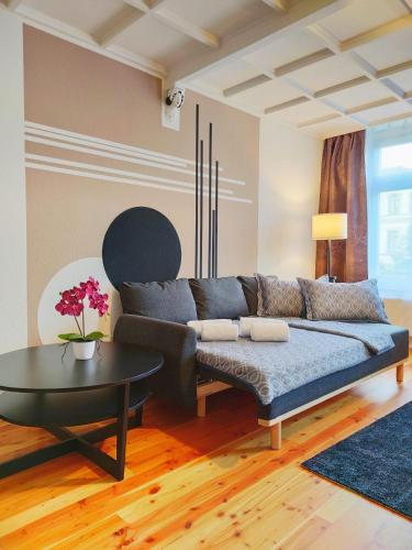 ein Wohnzimmer mit einem Sofa und einem Tisch in der Unterkunft Exclusive Suite South Central in Leipzig