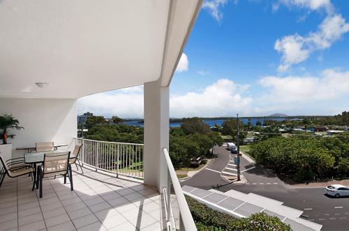 a balcony with a table and chairs and a view of a street at Rovera Apartments in Maroochydore