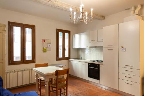 a kitchen with white cabinets and a table with chairs at Graceful apartment in the heart of Florence in Florence