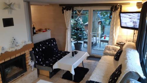 a living room with a fireplace and a christmas tree at Chata Iva Šírava in Vinné