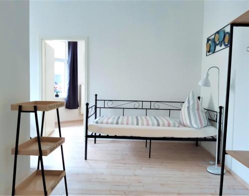 Schlafzimmer mit einem schwarzen Bett und einem Spiegel in der Unterkunft Citywohnung Südliche Innenstadt II in Halle an der Saale