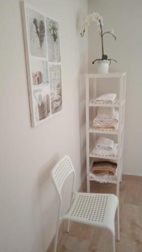 a white shelf and a chair in a room at El Corro, acogedora casa con jardín en el corazón de Cantabria in Villasuso de Cieza
