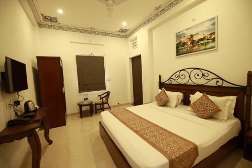 a hotel room with a bed and a television at Hotel Casa by the lake in Udaipur