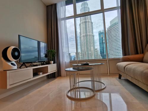 a living room with a couch and a tv at Sky Suites KLCC by Autumn Suites Premium Stay in Kuala Lumpur
