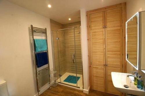 a bathroom with a shower with a glass door at Garden House at The Red House Estate in York