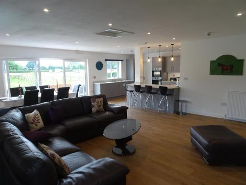a living room with a couch and a table and a kitchen at Garden House at The Red House Estate in York