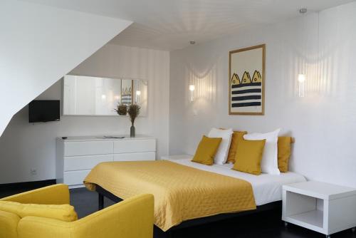 een slaapkamer met een geel bed en een gele stoel bij La Villa des Sables in Concarneau