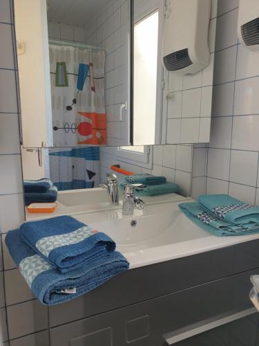 Un baño con lavabo, espejo y toallas. en Horizon, en bord de plage, en Marennes