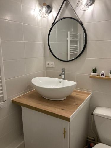 une salle de bain avec un lavabo blanc et un miroir dans l'établissement Studio mongie aux pieds des pistes avec balcon, à La Mongie