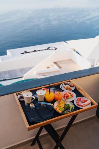 una bandeja de comida en una mesa en un barco en Santorini Secret Premium, en Oia