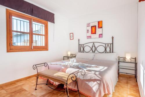 ein weißes Schlafzimmer mit einem Bett und einem Fenster in der Unterkunft Raiguer in Selva
