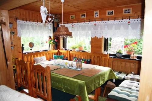 a dining room with a green table and chairs at Chalupa Dubková in Štôla