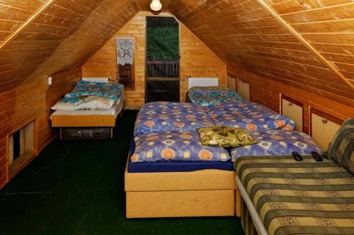 1 dormitorio con 2 camas en una cabaña de madera en Chalupa Dubková, en Lazy pod Makytou