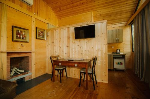 a dining room with a table and a fireplace at Rivel land in Tsʼkhmorisi