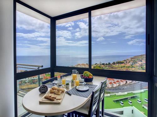 a table with food on it in a room with large windows at Heaven I by LovelyStay in Caniço