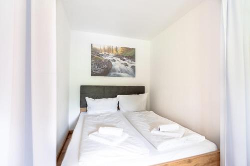 een slaapkamer met een bed met witte lakens bij Alpenblume in Fischen