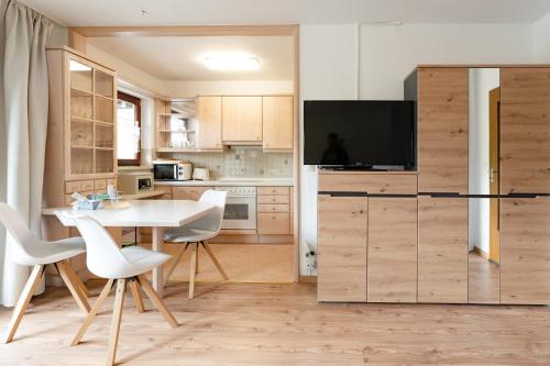 een keuken met een tafel en stoelen en een televisie bij Alpenblume in Fischen