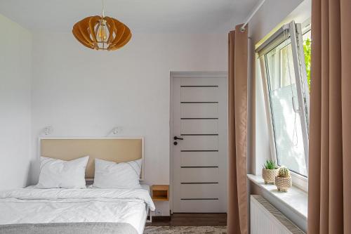 オストルフ・ビエルコポルスキにあるApartament AUGUSTYNのベッドルーム(ベッド1台、窓付)