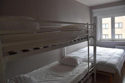 2 łóżka piętrowe w pokoju z oknem w obiekcie Valentino 0401 w mieście Koksijde