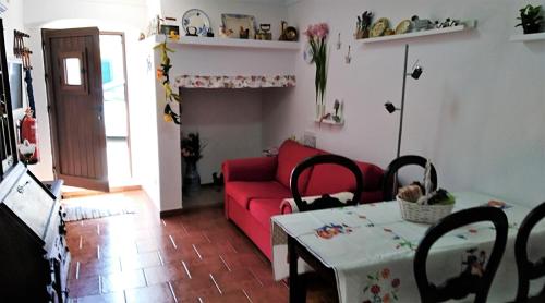 a living room with a red couch and a table at Casa BENVINDHA in Degolados