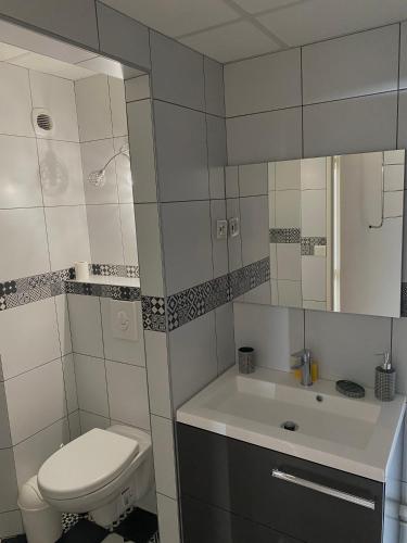 une salle de bain blanche avec des toilettes et un lavabo dans l'établissement Appartement 5min to DisneyLand, parking privé, à Magny-le-Hongre