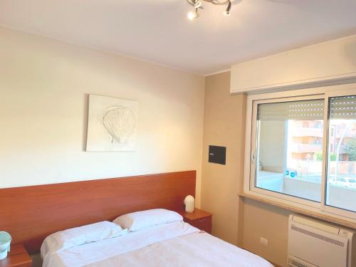 a bedroom with a bed and a window at Alghero Charming Apartments, Steps from the beach in Alghero