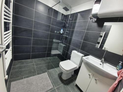 łazienka z toaletą i umywalką w obiekcie Sunny Garden Apartment w Bogácsu