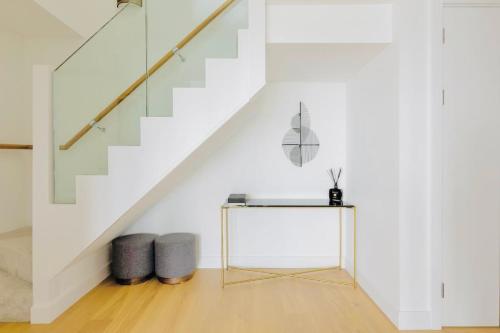 a white room with a table and stairs at Executive Waterfront Split Penthouse in Woolwich