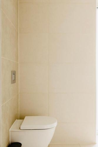 a bathroom with a white toilet in a room at Executive Waterfront Split Penthouse in Woolwich