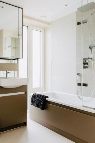 a bathroom with a sink and a bath tub at Executive Waterfront Split Penthouse in Woolwich