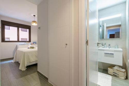 a bathroom with a sink and a room with a table at Teatinos Sky Garden II - CT 165 in Málaga