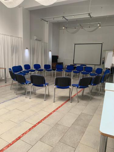 a conference room with blue chairs and a whiteboard at NB Hotel with Free Parking in Rīga