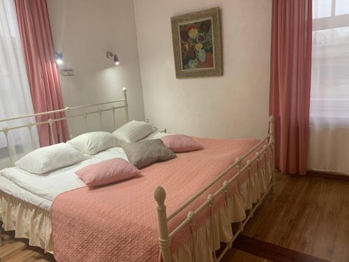 a bedroom with a large bed with pink and white pillows at NB Hotel with Free Parking in Rīga