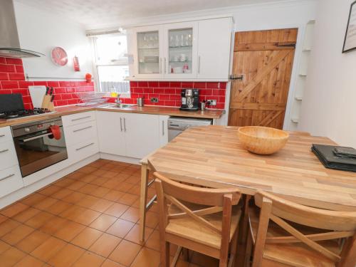 a kitchen with a wooden table and chairs in it at Tryfan in Caernarfon